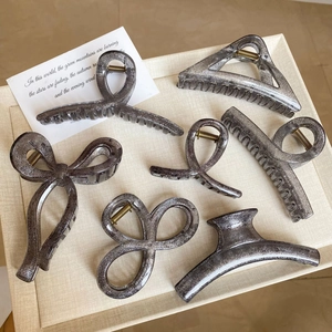 Detail von 6-teiligem Haarspangen-Set in glitzerndem Schwarz auf Beigem Tablett