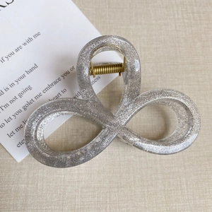 Detailaufnahme einer silbernen Glitzer-Haarklammer mit dreischleifigem Crossover-Design