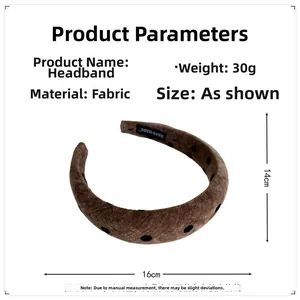 Detail view of coffee fabric headband with black polka dots showing size and texture