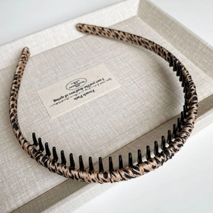 Close-up of leopard print fabric headband featuring inner black plastic non-slip teeth