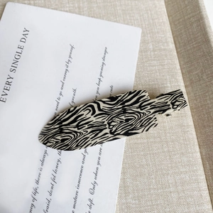 Close-up of zebra pattern hair clip on minimalist aesthetic background card