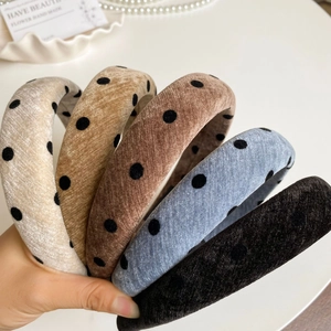 Detail of five vintage thick velvet headbands with classic black polka dots and soft texture