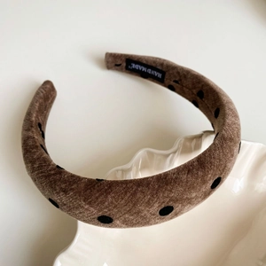 Detail of velvet polka dot headband with handmade label on a ceramic tray