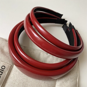 Detail view showing glossy red leather texture and non-slip black lining of headbands