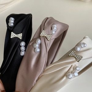 Three elegant French style pearl and bow satin headbands in black, pink, and cream white