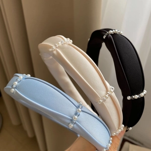Detail of padded satin headbands with white pearls and crystals in blue white and black