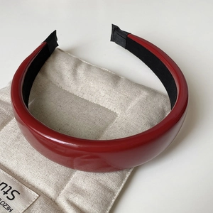 Close-up of wine red faux leather headband with glossy finish and anti-slip lining