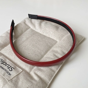 Close-up of vintage burgundy leather headband with anti-slip lining on quilted background
