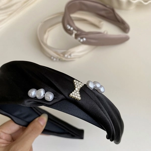 Detail of satin headbands with pearls and rhinestone butterflies in black, beige and brown
