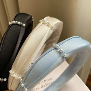 Elegant satin headbands with pearls and crystals in black, ivory, and sky blue colors