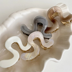 Set of four wavy acetate hair claws in white pearlescent grey and brown tones