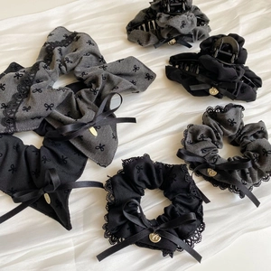 Grey and black bow hair accessories set with lace and gold charms on white fabric