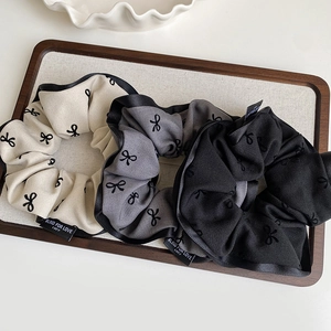Three-piece retro bow-print fabric scrunchie set in cream, grey and black with satin edges