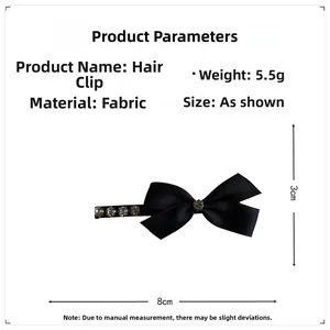 Dettaglio di un fiocco nero da 8cm con strass scintillanti e clip a becco d'anatra