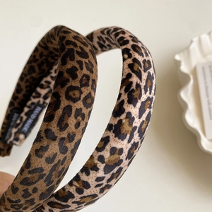 Detail showing plush leopard velvet texture and handmade label on stylish headbands