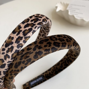 Macro detail of leopard print velvet headbands showing high-quality handmade inner tags