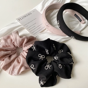 Détail de bandeaux et chouchous brodés avec nœuds en tissus rose et noir élégants