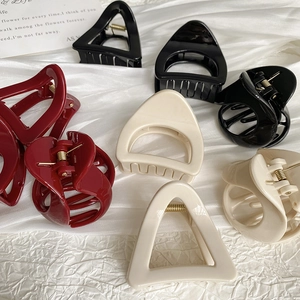 Pinces à cheveux triangulaires minimalistes en noir, crème et bordeaux sur tissu blanc