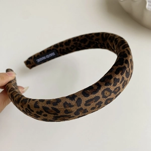 Detail shot of leopard print velvet headband with black handmade label on inner side