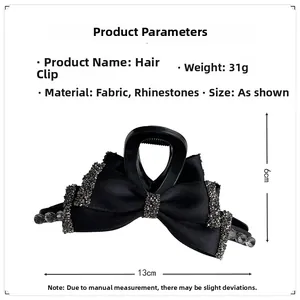 Detail view of black fabric bow hair claw with rhinestones showing 13cm length size