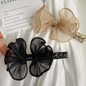 Detailed close-up of lace mesh bow hair clips with sparkling rhinestone accents