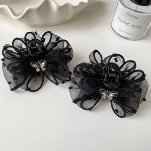 Detail shot of black polka dot mesh bow hair claw with sparkling silver rhinestone accents