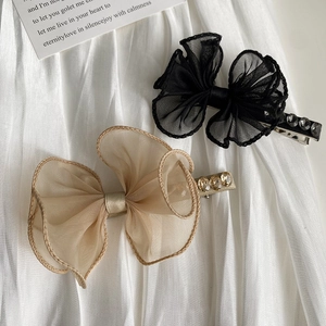 Detailed close-up of lace bow hair clips with sparkling rhinestones and organza texture