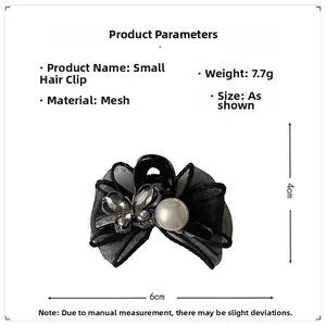 Detail view of 6cm black mesh bow hair claw clip with crystal butterfly and pearl accents