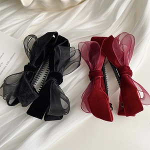 Détail de pinces à cheveux avec nœud en velours et organza noir et bordeaux chic