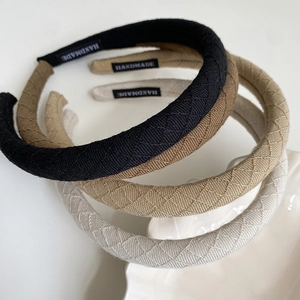 Quilted fabric padded headbands in assorted neutral colors with handmade labels