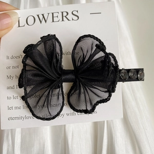 Detail view of black double-layered lace bow hair clip with three dark rhinestones