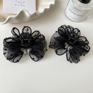 Detail of black polka dot mesh flower hair claws with rhinestone butterfly accents