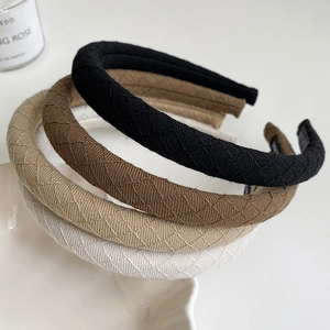 Detailed view of four quilted fabric headbands in black, coffee, khaki, and white colors