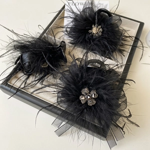 Close-up of black feather hair claw with elegant mesh and sparkling crystal rhinestones