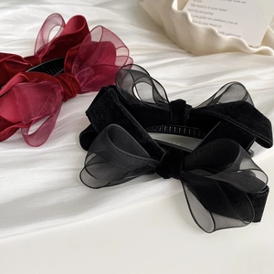 Détail de pinces à cheveux en velours et organza bordeaux et noir avec texture maille
