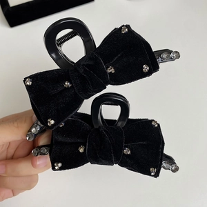 Close-up of black velvet bow hair claw clip with sparkling rhinestones details