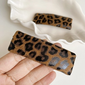 Close-up of leopard print rectangular hair clips with premium leather texture and matte finish