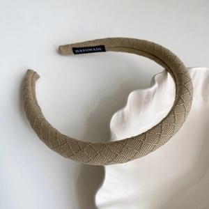 Detailed macro view of khaki fabric headband featuring premium woven diamond texture