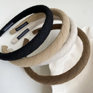 Detailed macro view of quilted fabric headbands featuring handmade labels in soft colors
