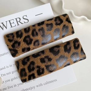 Close-up of two rectangular leopard print hair clips with velvet texture on card