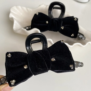 Detail of black velvet bow hair claw clip with shimmering rhinestones and large crystals