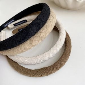 Close-up of fabric headbands with quilted rhombus texture and handmade label