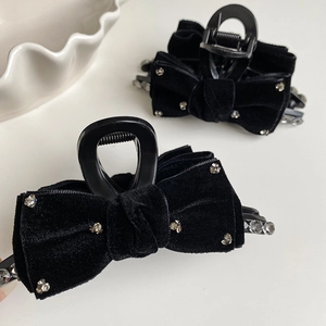 Detailed macro view of black velvet bow hair claw clip with shimmering rhinestones inlay
