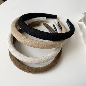 Close-up of four quilted padded headbands in black, beige, khaki and coffee brown colors