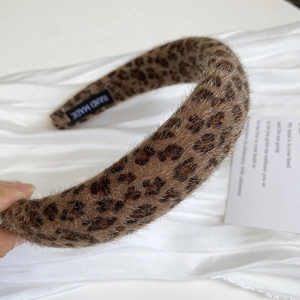 Detail of plush leopard print headband featuring a handmade label on velvet lining