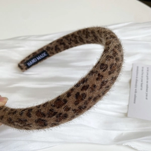 Detail of plush leopard print headband featuring a hand made woven label for quality