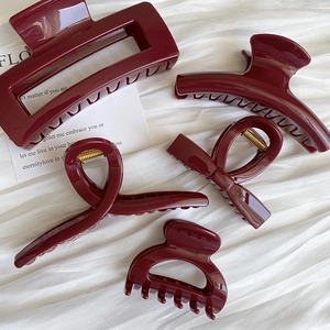 Detailed set of five deep red glossy hair claws in various geometric and bow shapes