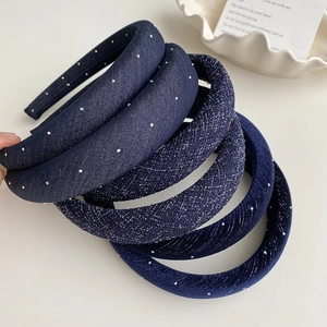 Détail de serre-têtes rembourrés bleu marine avec strass brillants et textures satinées