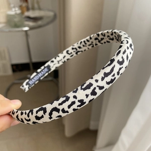Detailed view of the handmade leopard print sponge headband with a high-quality fabric tag