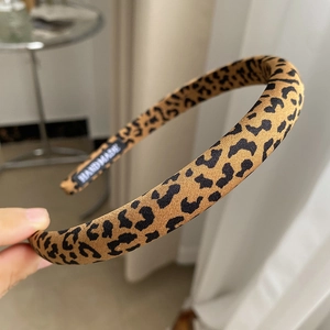 Close-up of leopard print headband texture featuring a black handmade woven label inside